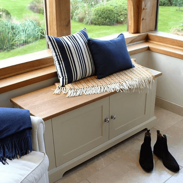 This shoe storage bench is a low lying cupboard with Shaker style doors. The top surface is made of oak making it a durable to sit on while your change into your footwear.