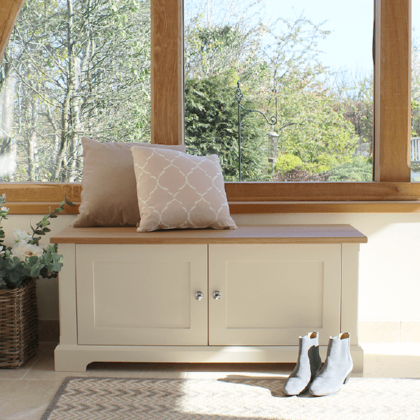 This shoe storage bench is a low lying cupboard with Shaker style doors. The top surface is made of oak making it a durable to sit on while your change into your footwear.